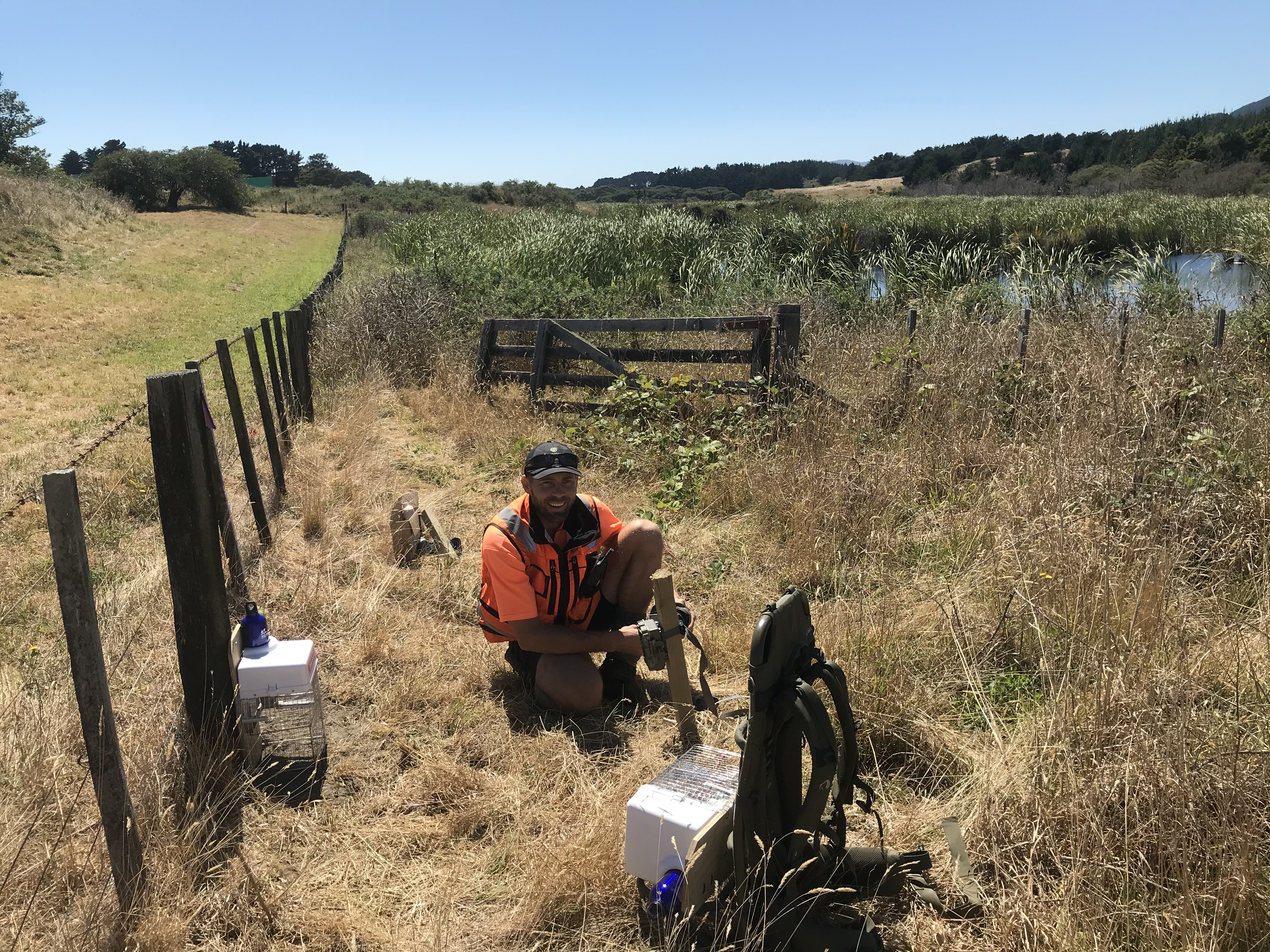 A man in hi-vis with water monitoring equipment in a wetland