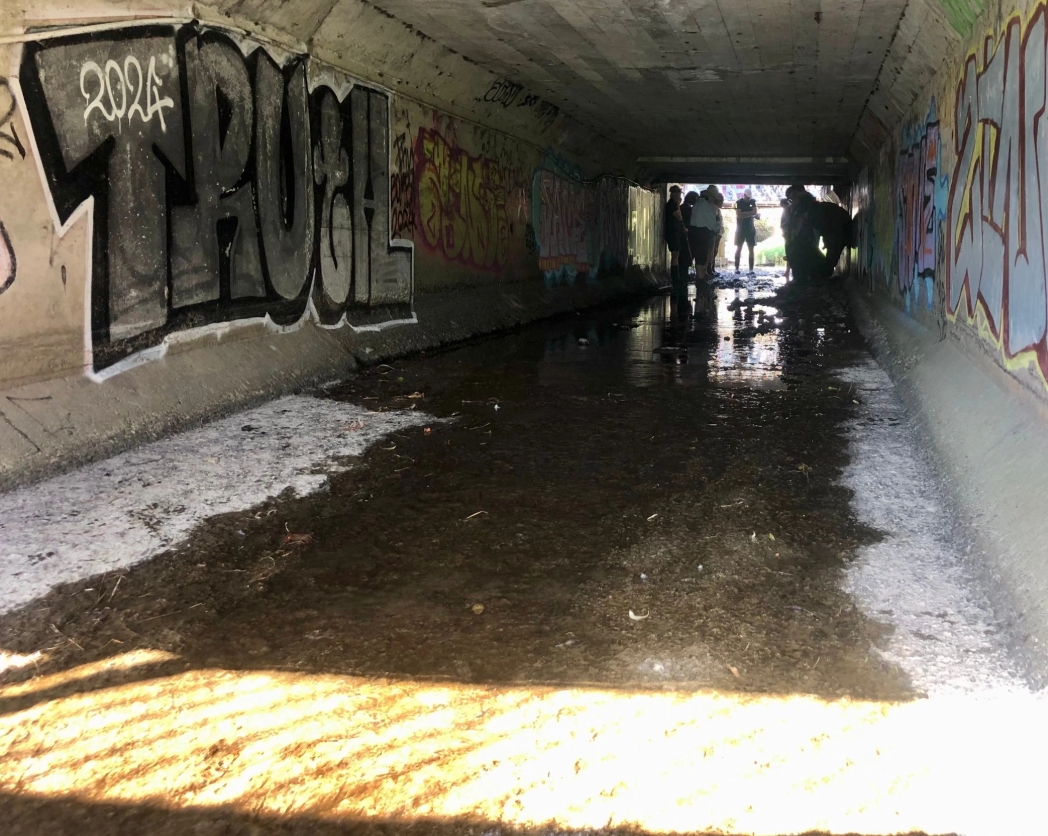 A concrete underpass people gathered at one end