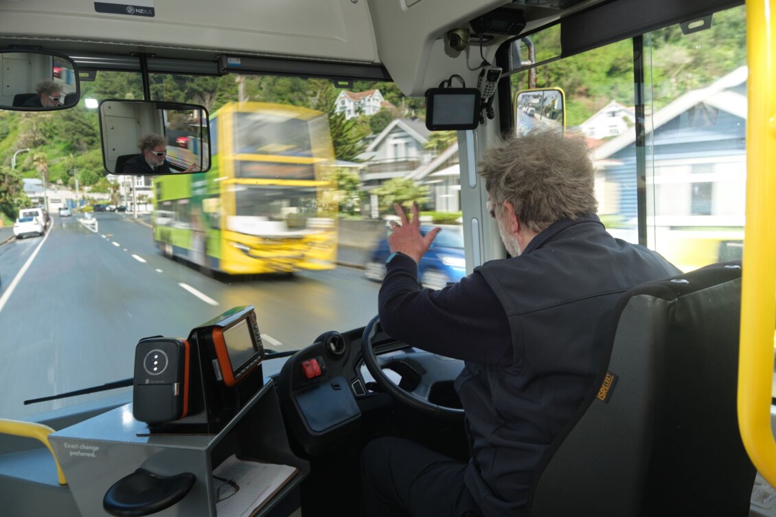 Metlink bus driver Peter, driving down a suburban street and waving at a passing bus