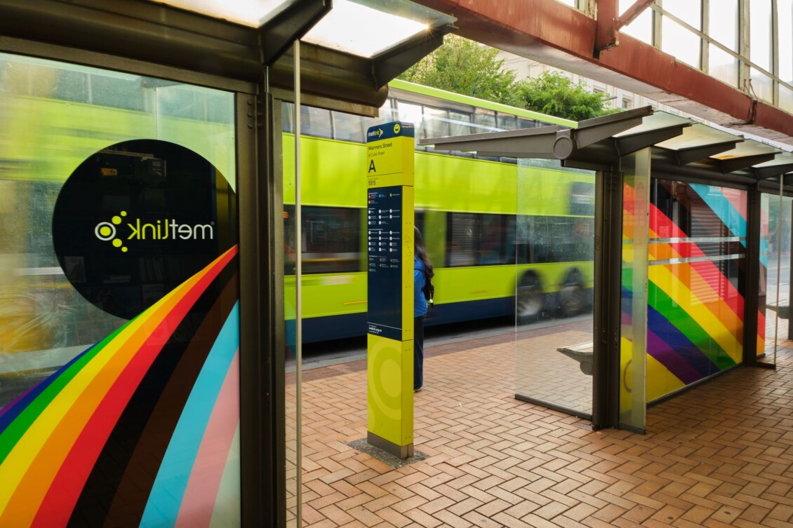 The rainbow bus stop at Manners St, with colours of the progress pride flag curving across it